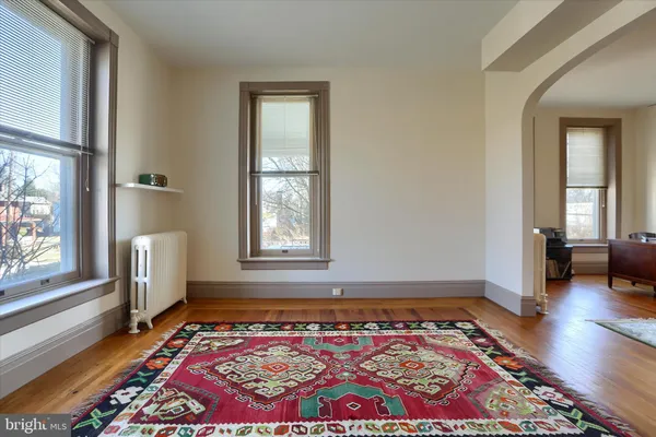 a bedroom with wooden floor and entrance