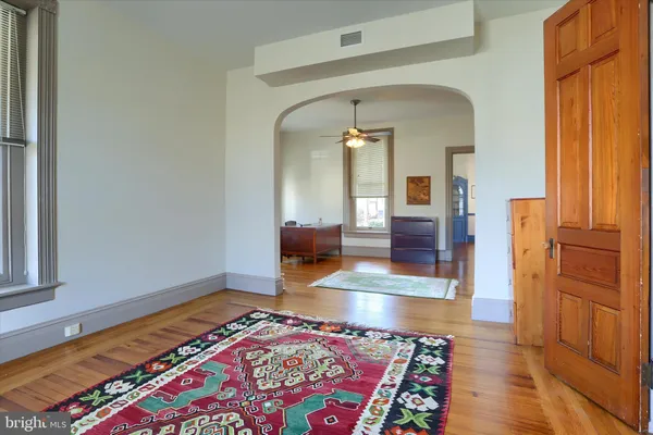 a bedroom with natural light and wooden floor