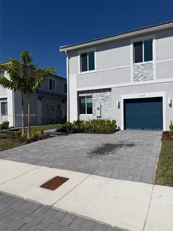 a front view of a house with a yard and a garage