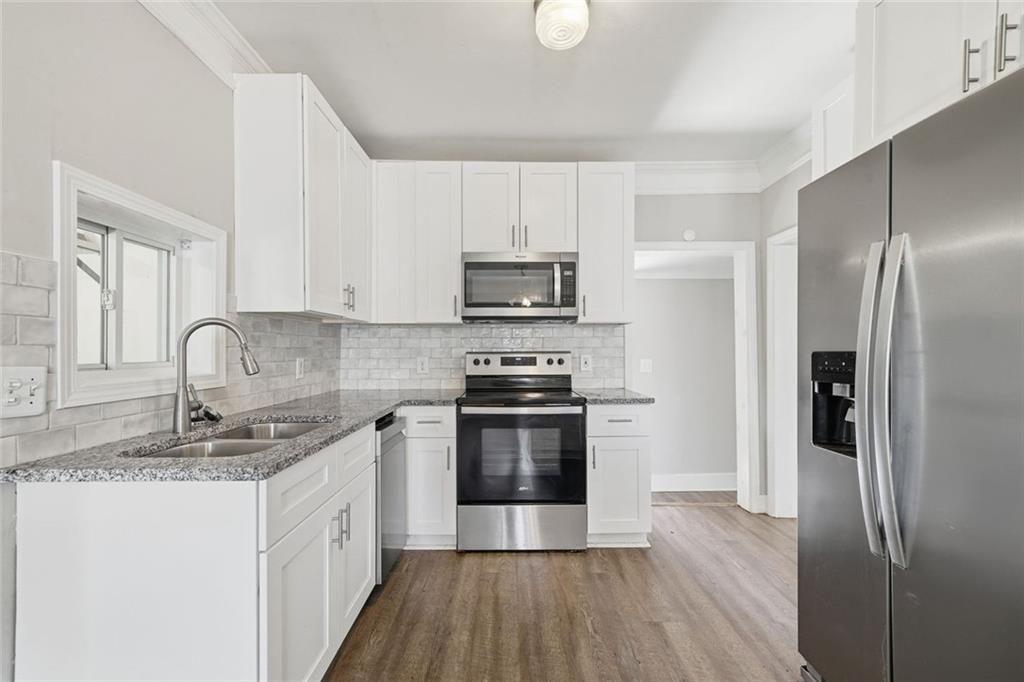174 Cherokee Avenue Nelson, GA 30151 - Photo 17 of 28 a kitchen with granite countertop a stove top oven a sink and a refrigerator