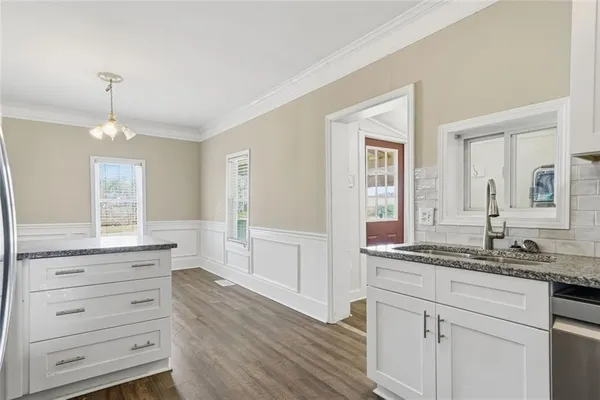 a kitchen with granite countertop a sink and cabinets