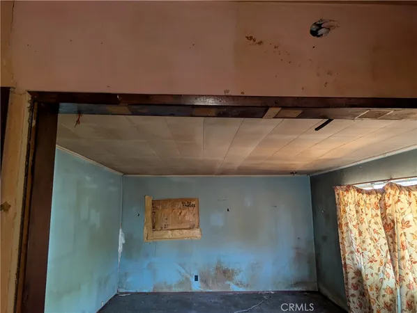 a view of a hallway and a livingroom with furniture