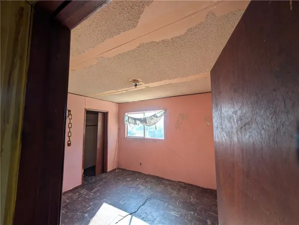 a view of empty room with wooden floor and windows