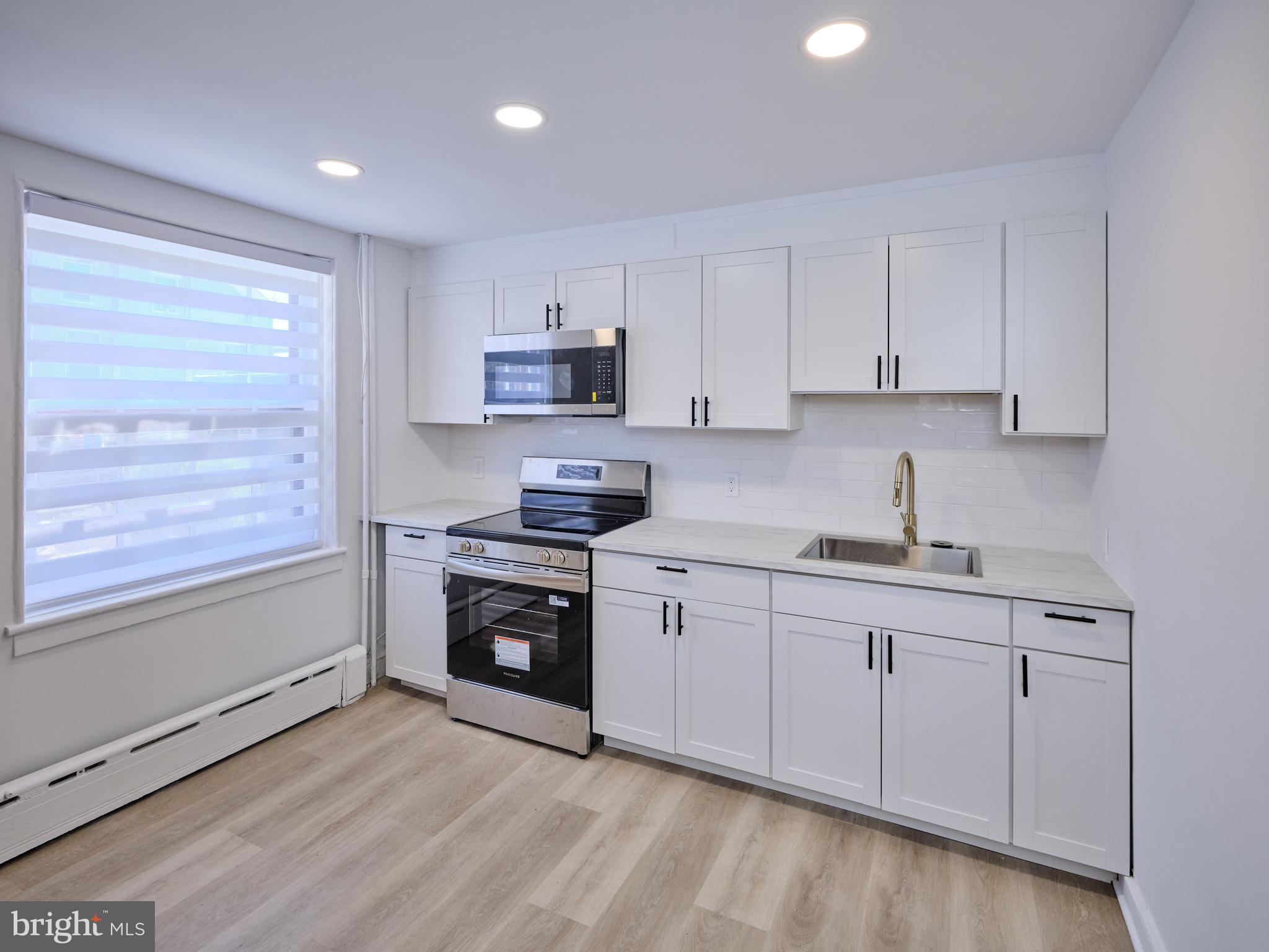 a kitchen with stainless steel appliances granite countertop a sink a stove and a refrigerator