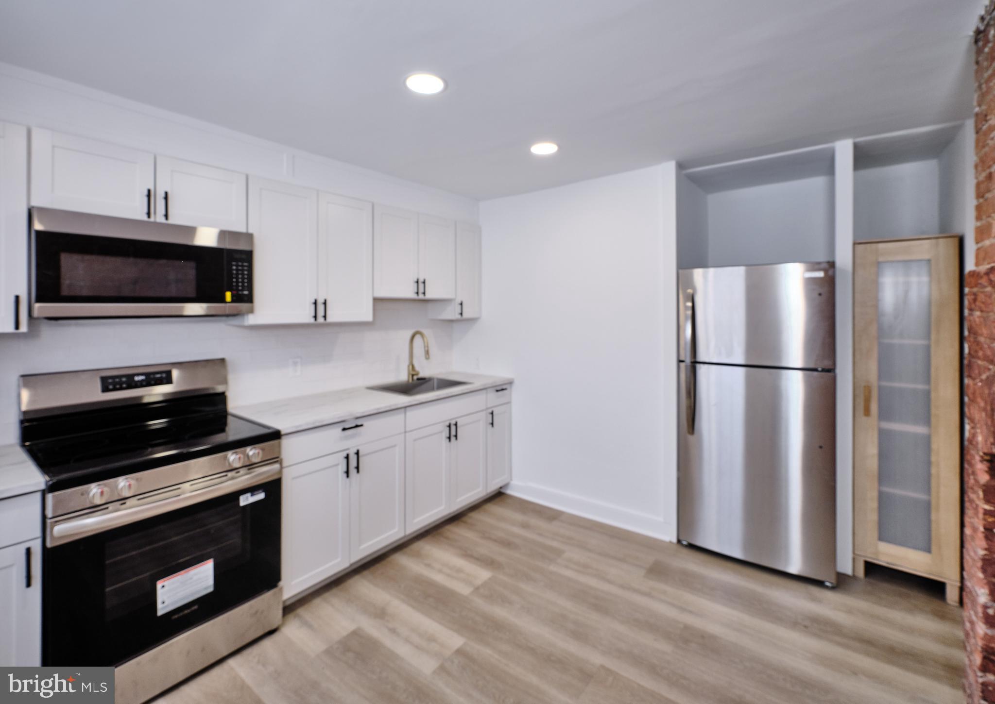 14 West Bridge Street, Unit A New Hope, PA 18938 - Photo 11 of 24 a kitchen with stainless steel appliances a refrigerator stove and microwave