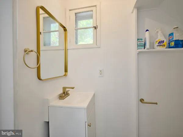 a bathroom with a sink and mirror with window