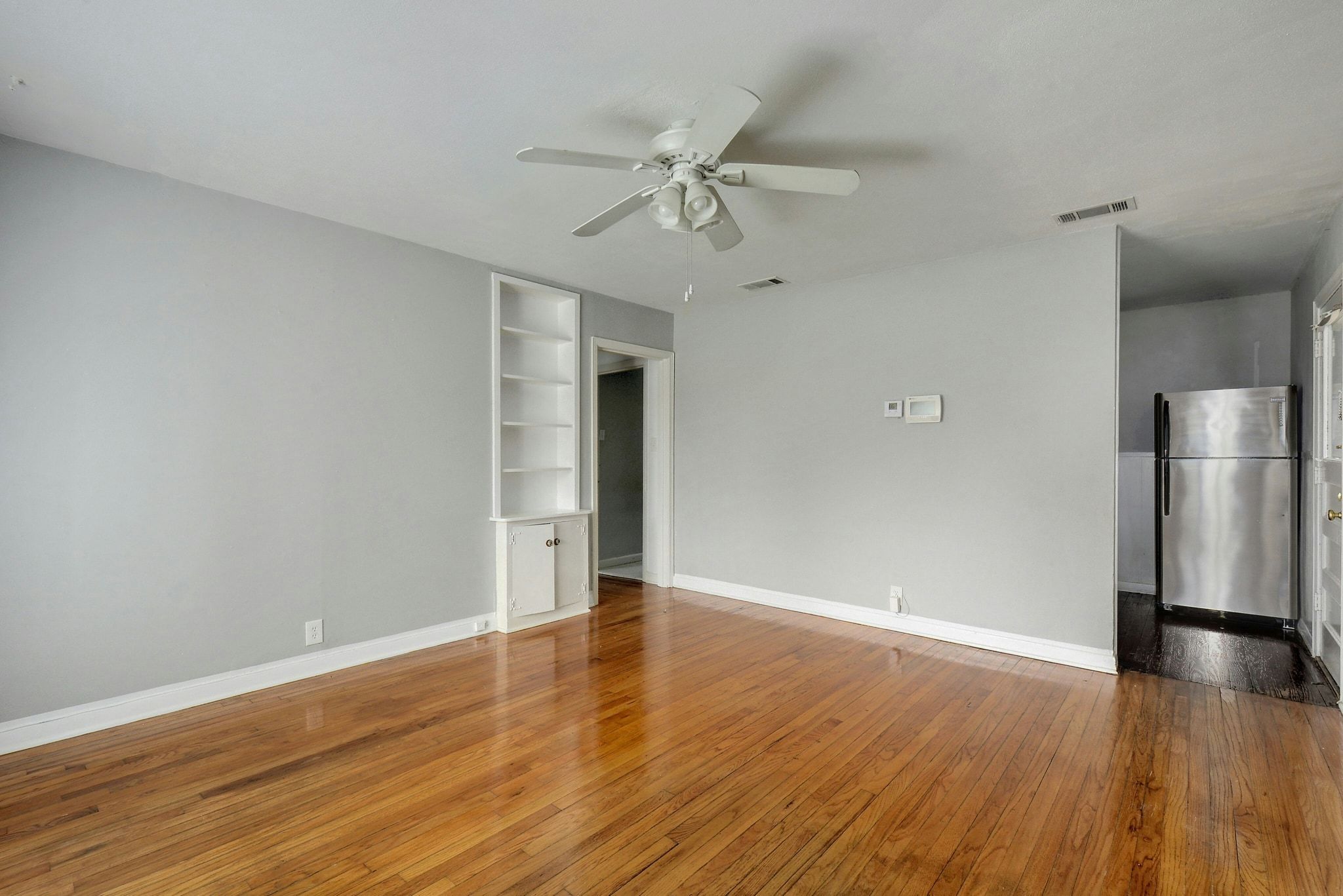 907 East 56th Street Austin, TX 78751 - Photo 7 of 20 a view of an empty room with wooden floor and a ceiling fan