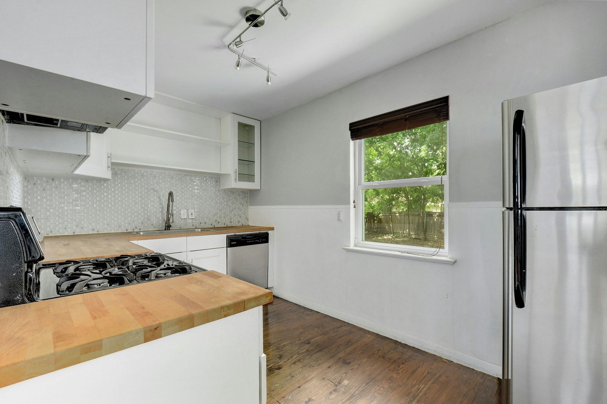 907 East 56th Street Austin, TX 78751 - Photo 8 of 20 a kitchen with a stove a refrigerator and a sink with wooden floor