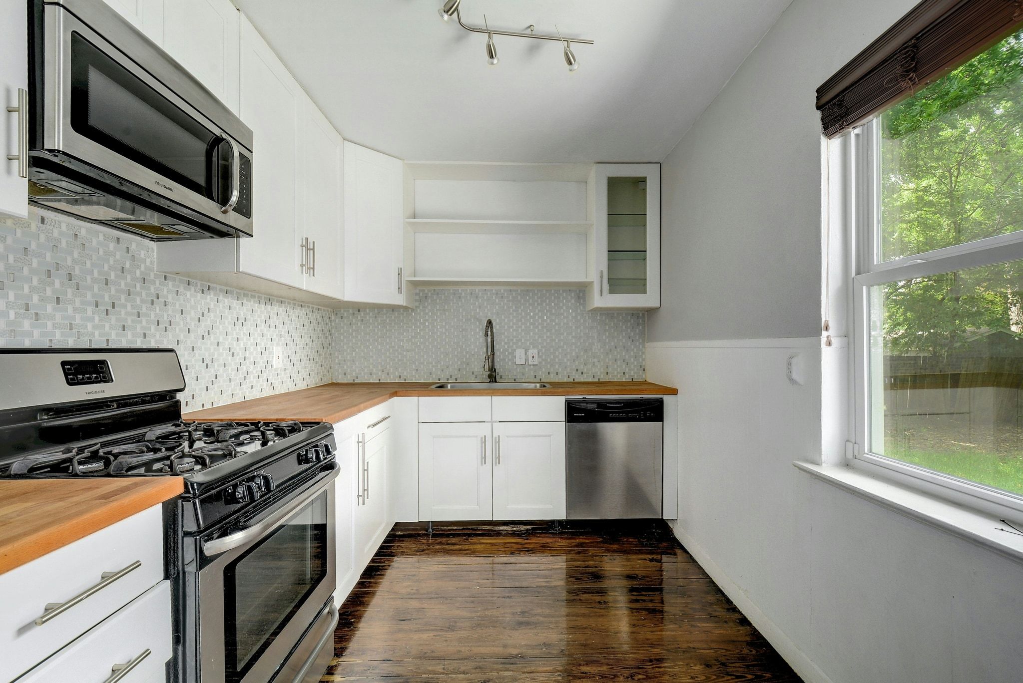 907 East 56th Street Austin, TX 78751 - Photo 9 of 20 a kitchen with stainless steel appliances a sink a stove a microwave and cabinets