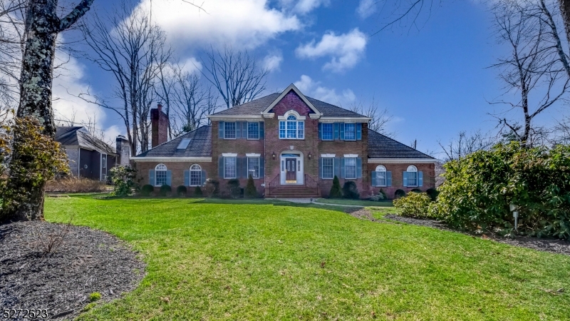 a view of a big house with a big yard and large trees