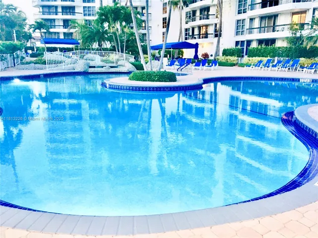 a view of swimming pool in front of residential houses with outdoor seating