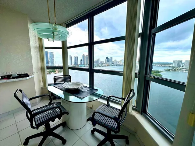 a view of a dining room with furniture large windows and wooden floor
