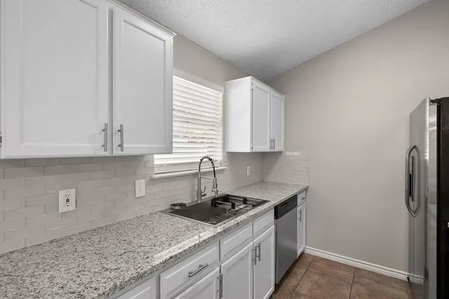 a kitchen with a sink cabinets and a window