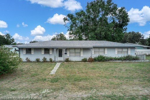 1221 Forest Road Sebring, FL 33872 - Photo 1 of 31 a front view of a house with a yard and garage