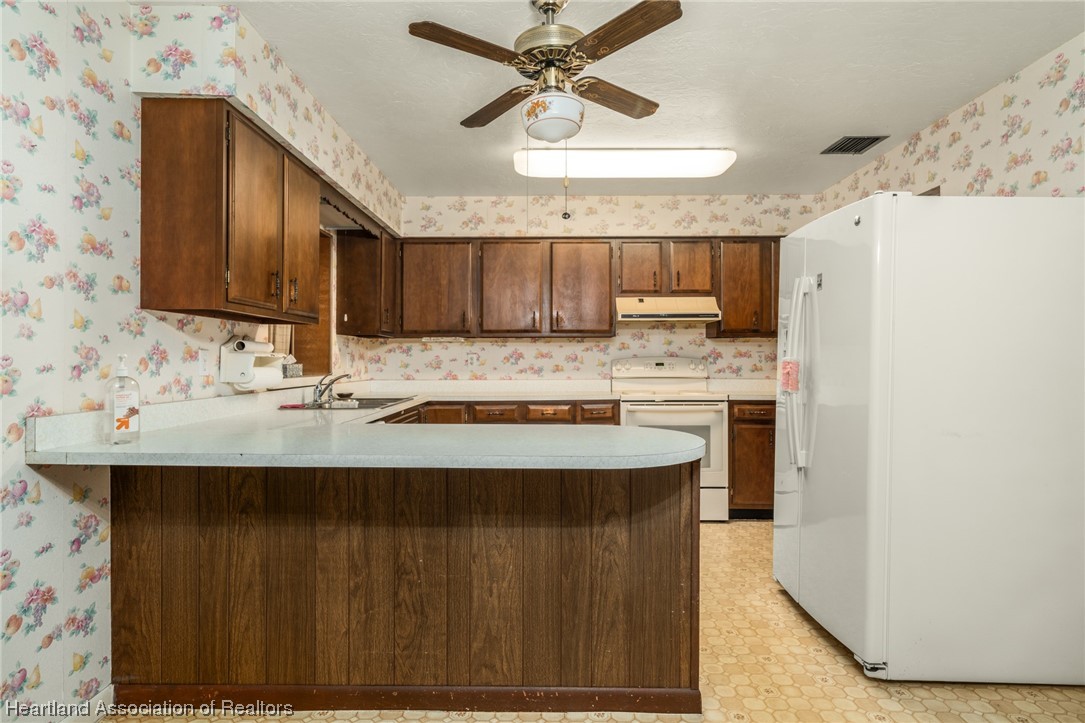 1221 Forest Road Sebring, FL 33872 - Photo 13 of 31 a kitchen with stainless steel appliances granite countertop a sink stove and refrigerator