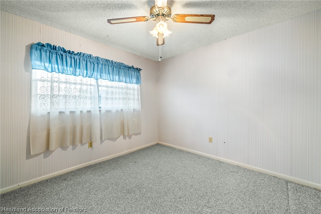1221 Forest Road Sebring, FL 33872 - Photo 22 of 31 an empty room with chandelier fan and windows