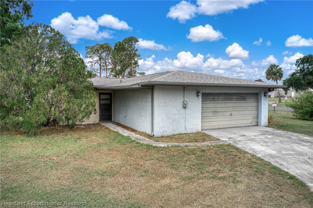 1221 Forest Road Sebring, FL 33872 - Photo 6 of 31 a view of a house with a yard and garage