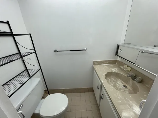 a bathroom with a granite countertop sink toilet and mirror