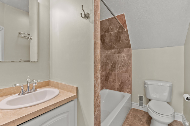 148 South 300 East Logan, UT 84321 - Photo 16 of 29 Full bathroom featuring a white vanity with an oval sink and a light-toned countertop, a tiled shower/tub combination, a toilet, and light-colored wall paint