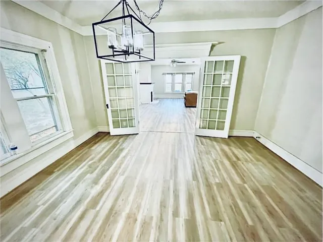 a view of empty room with wooden floor