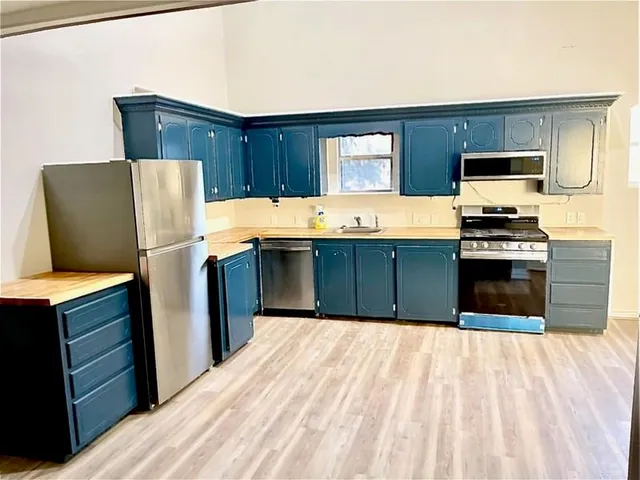 a kitchen with stainless steel appliances granite countertop a refrigerator stove and sink