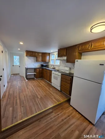 a kitchen with a refrigerator and a stove top oven