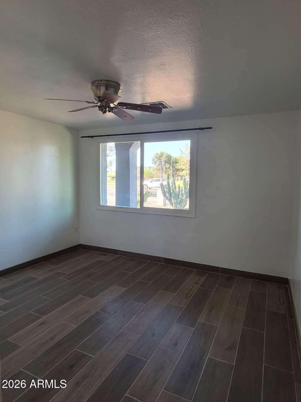 3702 East Thunderbird Road Phoenix, AZ 85032 - Photo 11 of 23 an empty room with wooden floor chandelier fan and windows
