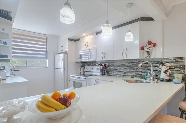 a kitchen with white cabinets and white appliances