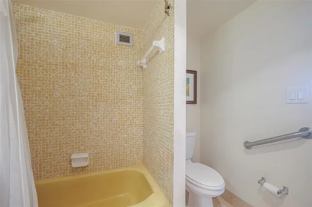 a view of a houses with a yard and palm trees