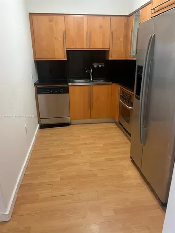 a kitchen with stainless steel appliances a refrigerator a sink a stove and a microwave