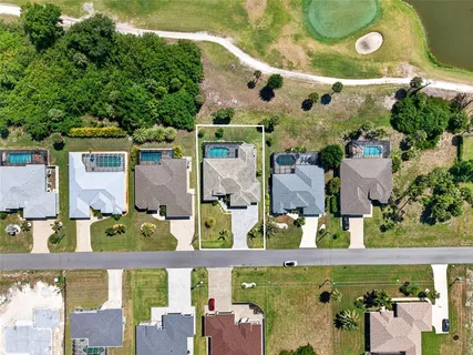 an aerial view of a city with lots of residential buildings ocean and mountain view in back