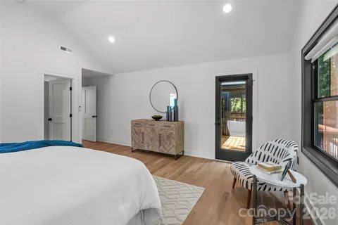a bedroom with a bed and a dresser with mirror