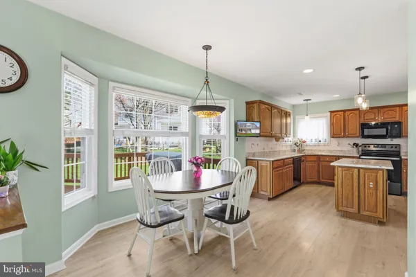 a kitchen with a dining table chairs and refrigerator