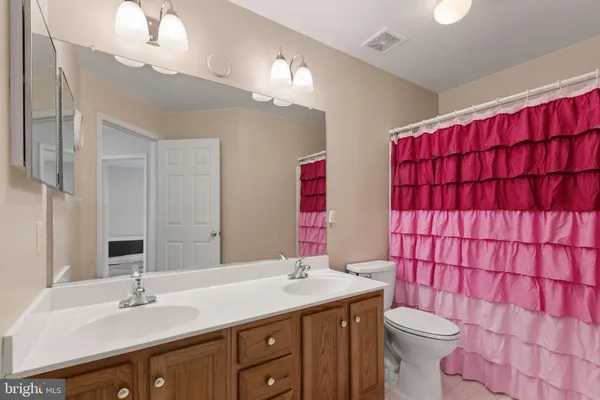 a bathroom with a sink vanity mirror and toilet