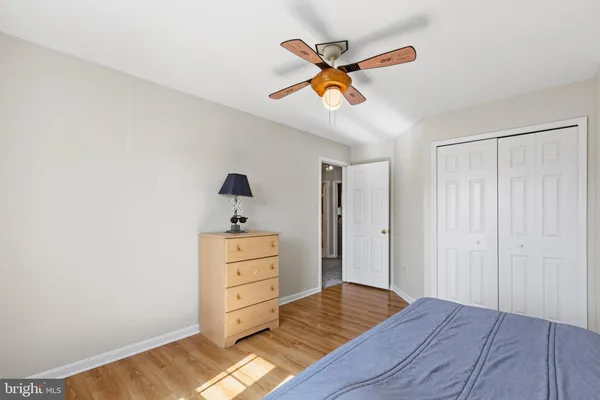 a view of a bedroom with wooden floor and ceiling fan