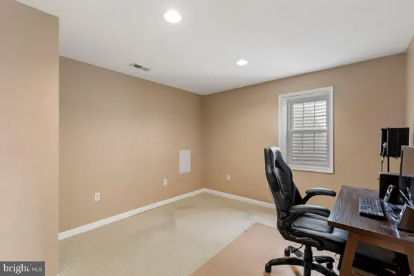 a view of a workspace with furniture and a window