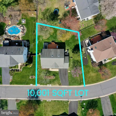 an aerial view of a house with a yard and a large pool