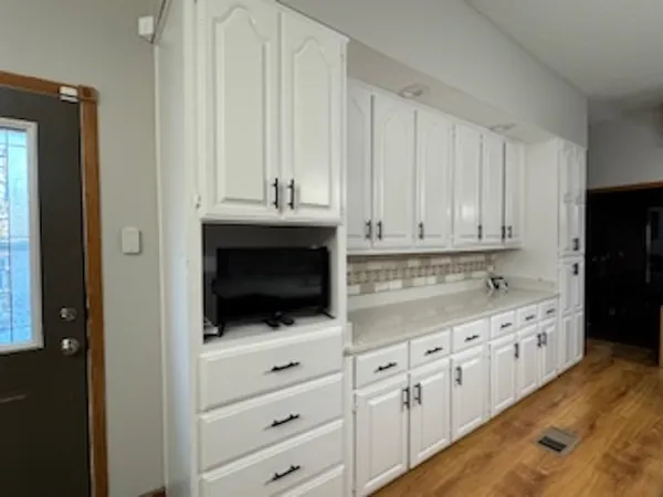 a kitchen with white cabinets and sink