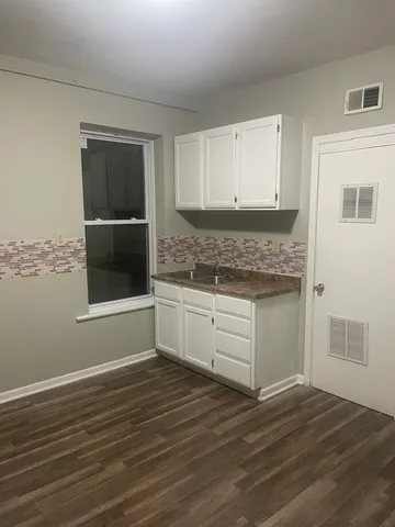 a kitchen with granite countertop wooden cabinets and white appliances