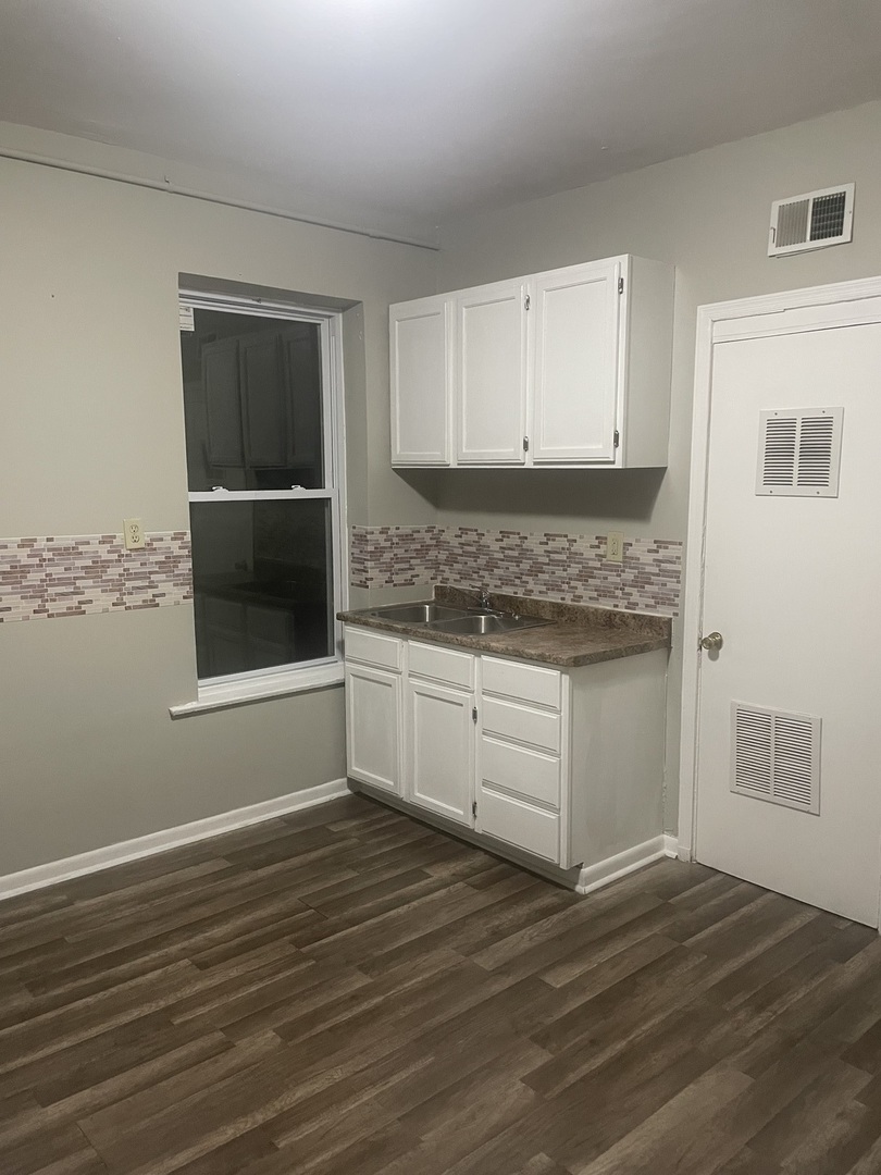 451 East 111th Street, Unit 3R Chicago, IL 60628 - Photo 2 of 7 a kitchen with granite countertop wooden cabinets and white appliances