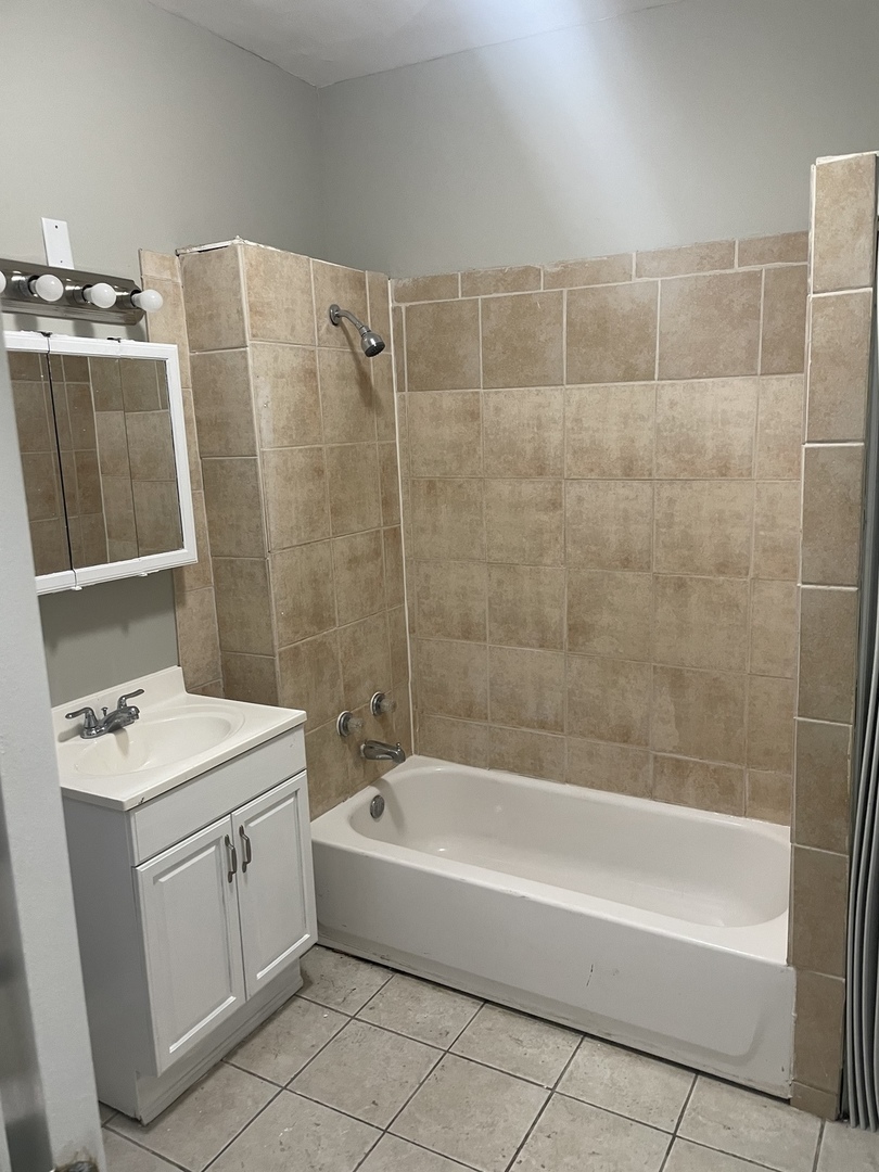 451 East 111th Street, Unit 3R Chicago, IL 60628 - Photo 5 of 7 a bathroom with a bathtub a sink a toilet and a mirror