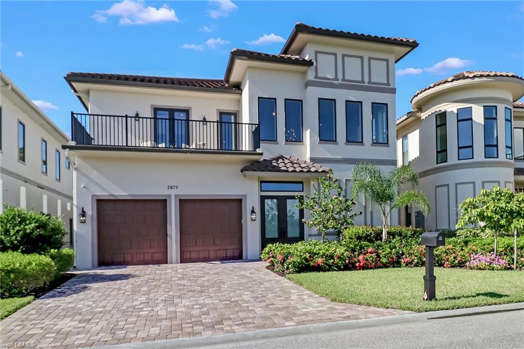 Mediterranean / spanish house with a garage, a balcony, a front yard, and french doors