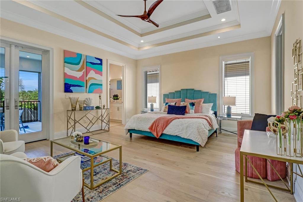 2875 Coco Lakes Drive Naples, FL 34105 - Photo 21 of 27 Bedroom featuring access to exterior, a tray ceiling, ceiling fan, crown molding, and light hardwood / wood-style flooring