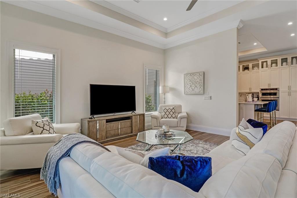 2875 Coco Lakes Drive Naples, FL 34105 - Photo 9 of 27 Living room with a raised ceiling, ceiling fan, light hardwood / wood-style floors, and ornamental molding
