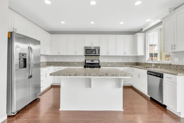 a kitchen with stainless steel appliances granite countertop a stove a sink and a refrigerator