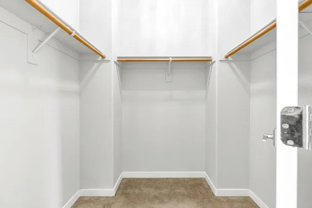a view of walk in closet with clothes and window