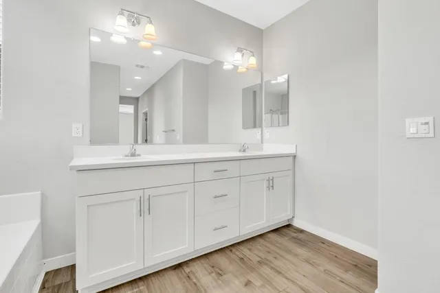 a bathroom with a double vanity sink and a mirror