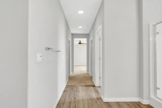 a view of a hallway with wooden floor