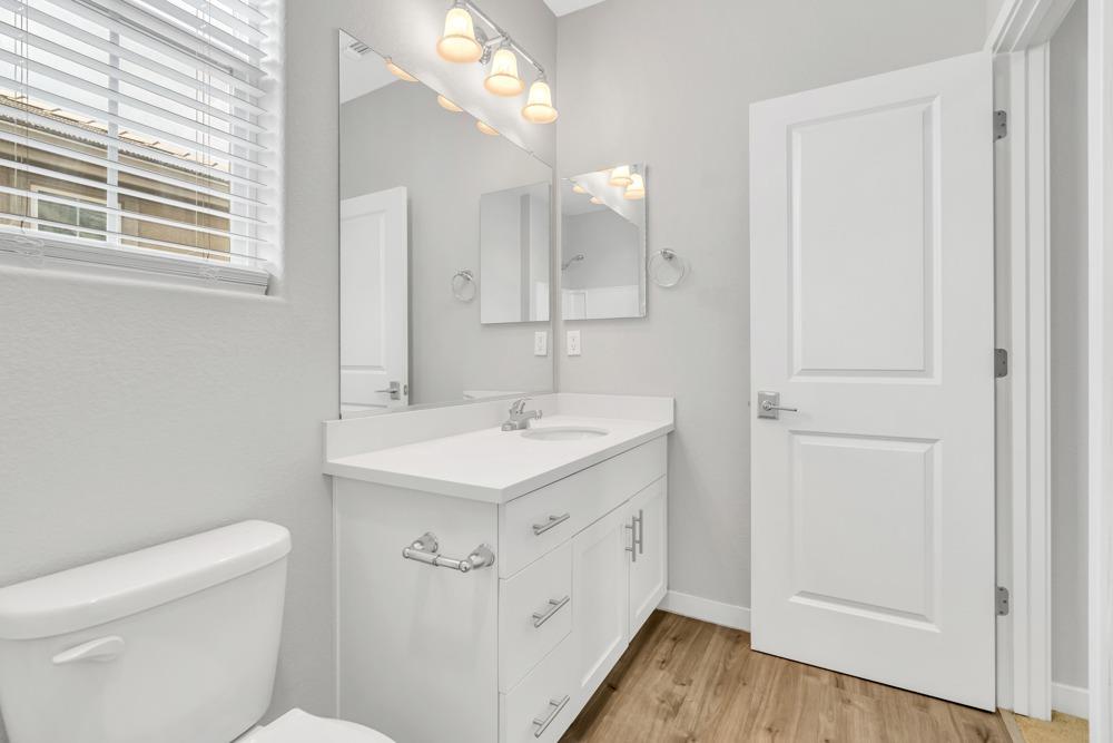 9433 Vintner Circle Patterson, CA 95363 - Photo 36 of 51 a spacious bathroom with a sink a toilet and a mirror