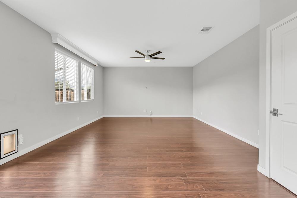 9433 Vintner Circle Patterson, CA 95363 - Photo 7 of 51 an empty room with wooden floor and windows